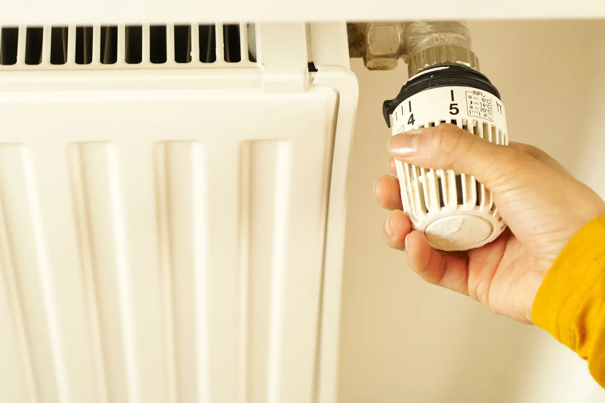 Hand turning a thermostatic radiator valve