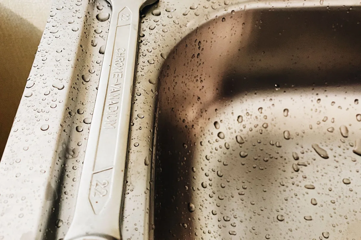 Spanner resting in a wet steel sink