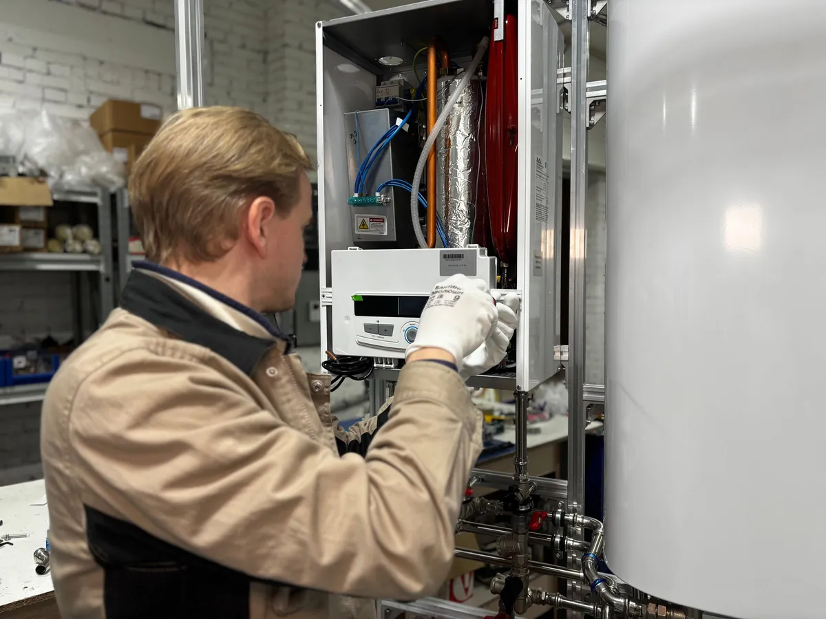 Heating engineer checking a wall-mounted gas boiler