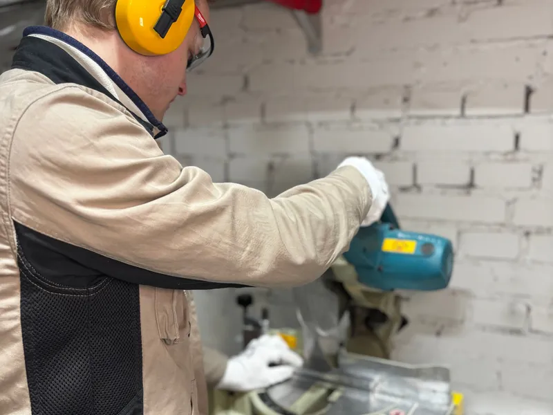 Engineer drilling a wall with ear defenders on