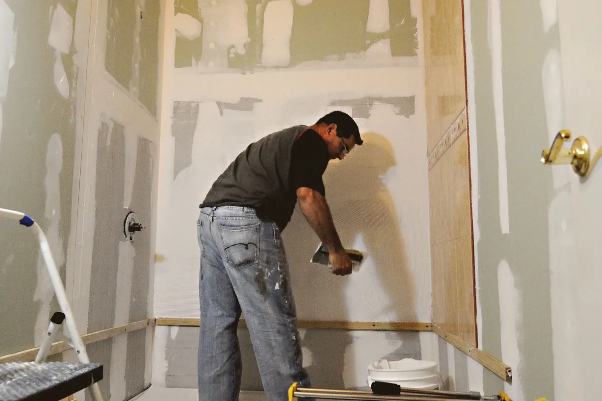 Fitter boarding out a bathroom before tiling